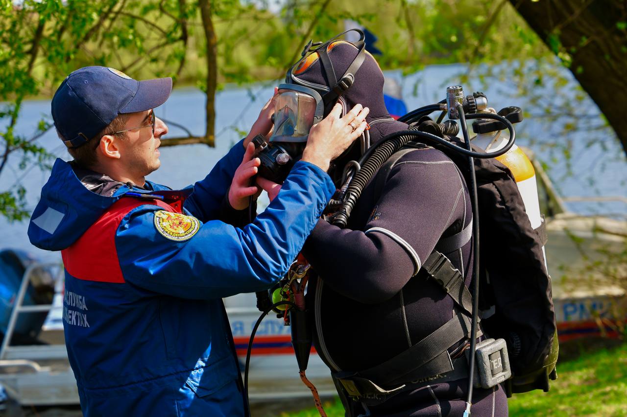 Спасатель помогает коллеге надевать снаряжение для погружения под воду