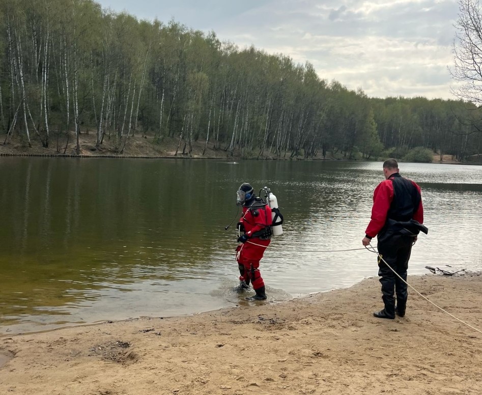 Спасатель спускается в воду, его коллега страхует